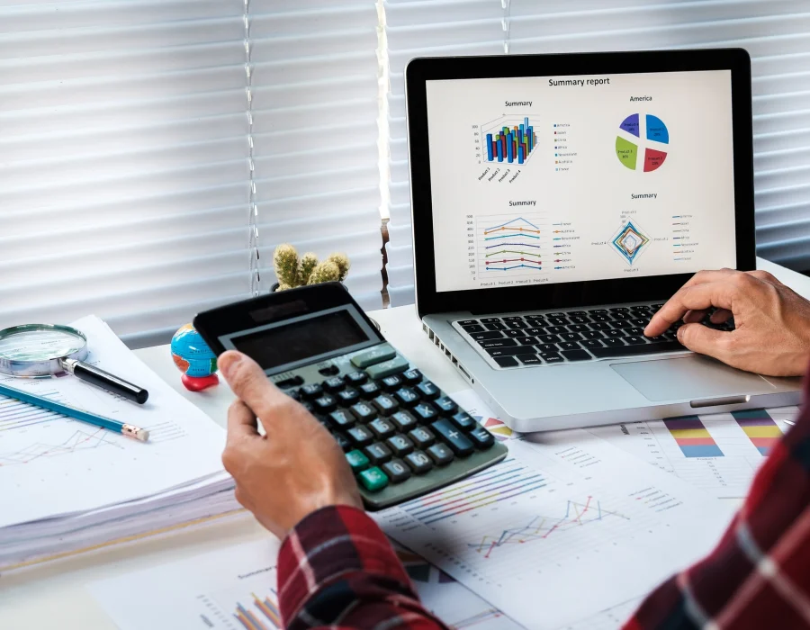 businessman-analyzing-investment-charts-with-laptop-calculator-office-desk-table